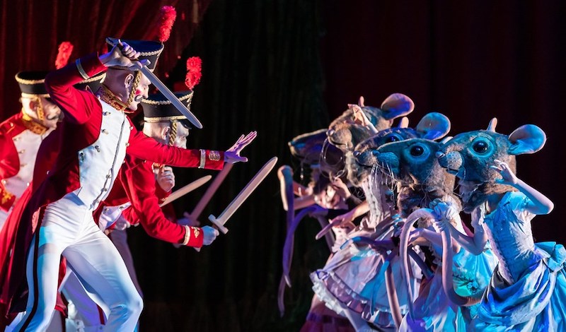 Ballet troopers with play swords fight ballet mice with big heads and long tails.